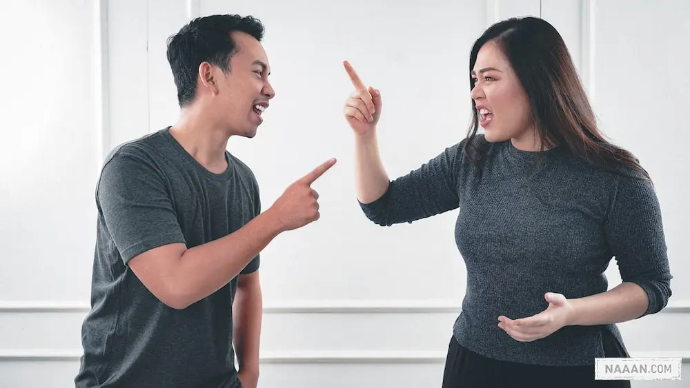 man in gray crew neck long sleeve shirt standing beside woman in black crew neck shirt