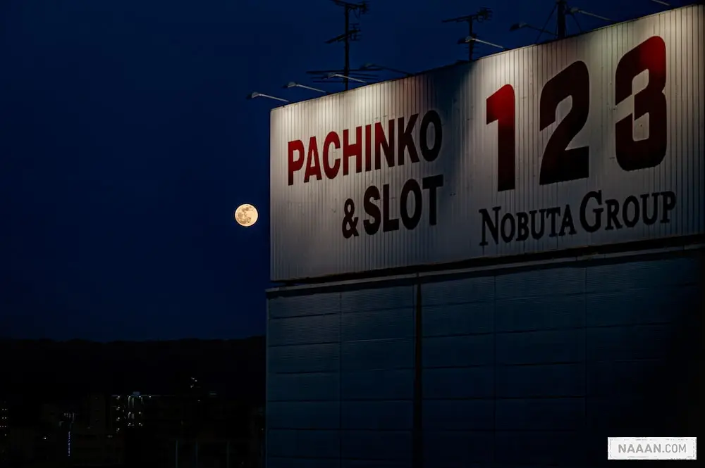 a full moon is seen behind a sign