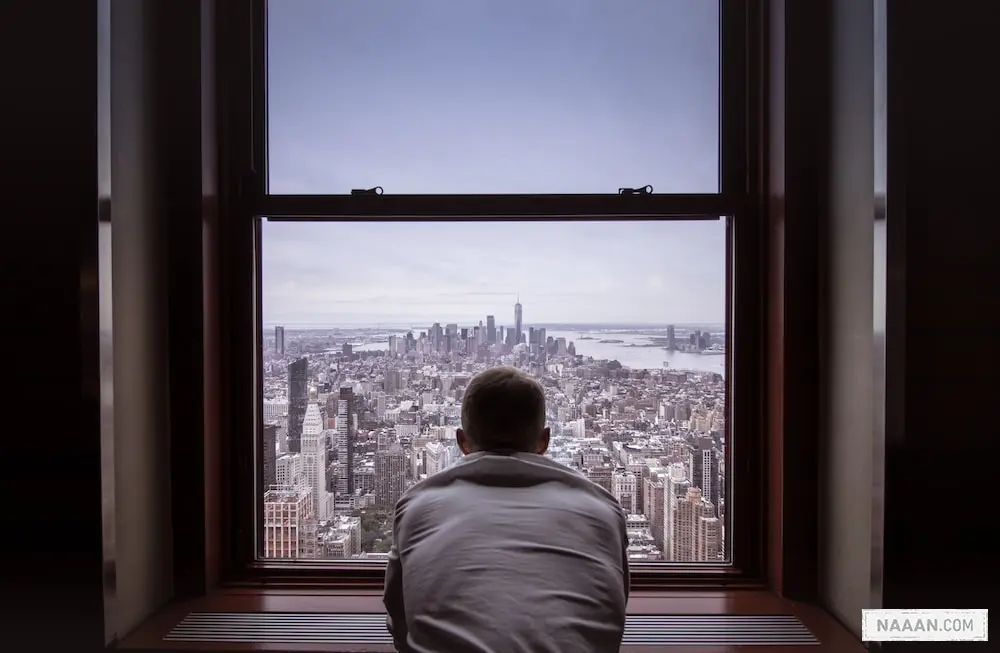man in gray shirt looking at city buildings during daytime